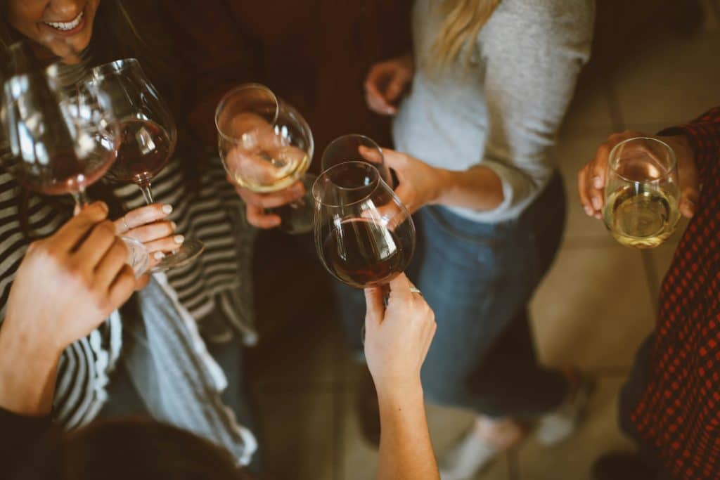 Friends gathered together holding wine glasses, sharing a relaxed moment of connection and enjoyment