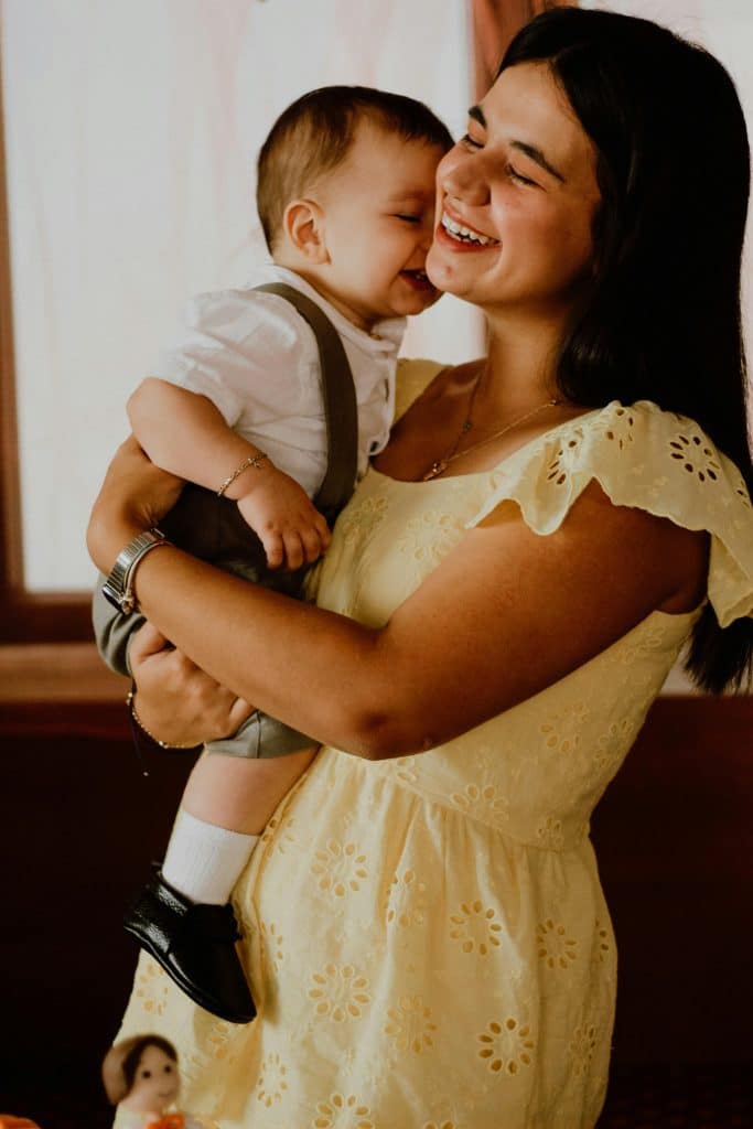 Adult holding a young child in a relaxed home setting, sharing a calm and secure moment together