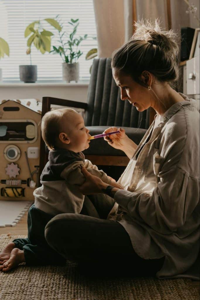 Caregiver providing childcare support at home while caring for a sick baby