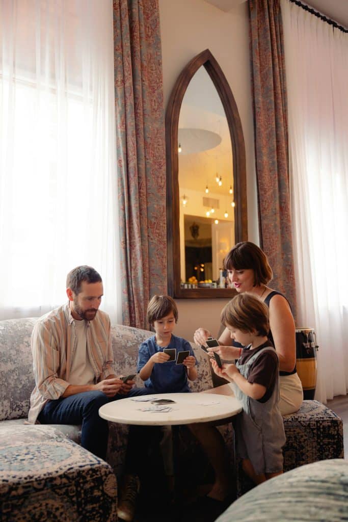 Family spending time together at home while parents manage routines and childcare coordination in a calm, well supported household