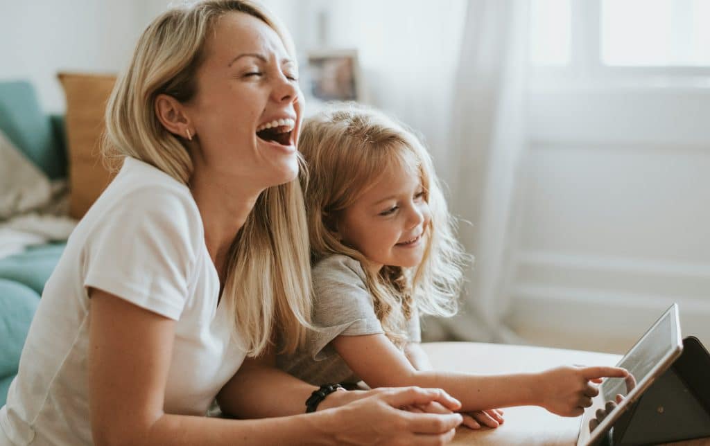 Mother and young child sitting together at home, relaxed and engaged, reflecting a calm household supported by intentional systems rather than constant effort