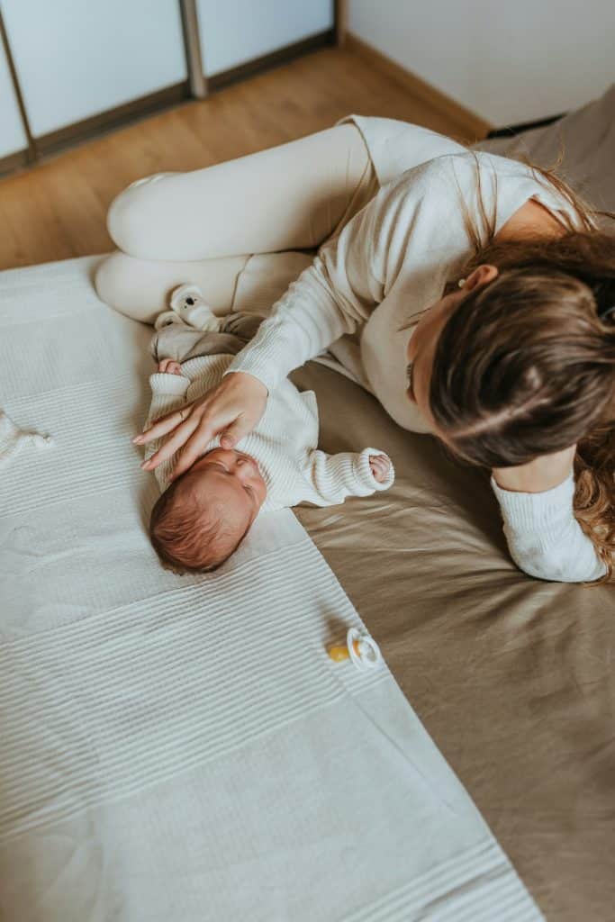 Parent resting with an infant at home, reflecting the stability created by reliable childcare support and well designed household systems