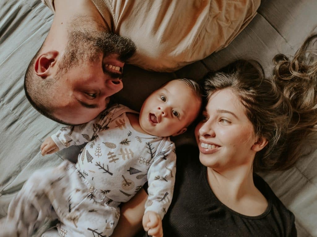 A joyful family lying together, sharing an intimate and peaceful moment, exemplifying the importance of nurturing and supportive relationships in the home