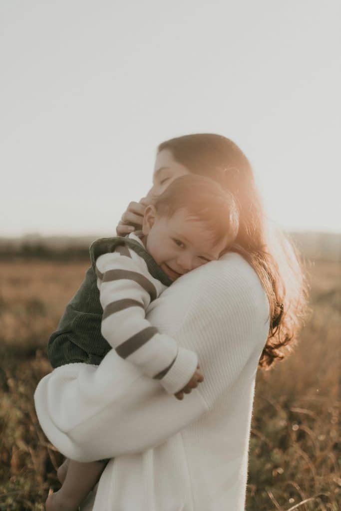 A parent holds their child tenderly, embodying the comfort and security that thoughtful childcare placement brings