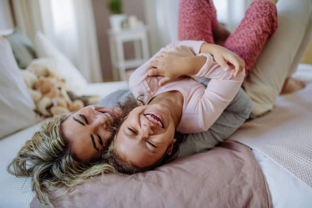 Mother laughing with her child during a relaxed morning at home while school is closed