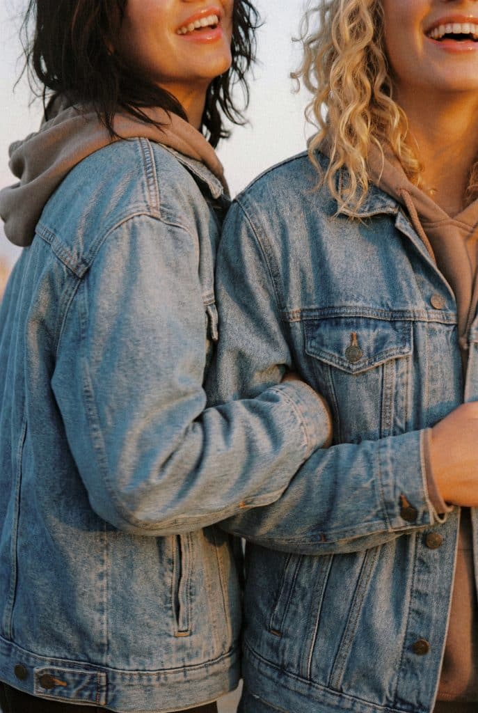 Two women standing together smiling, representing connection, support, and community in women’s health