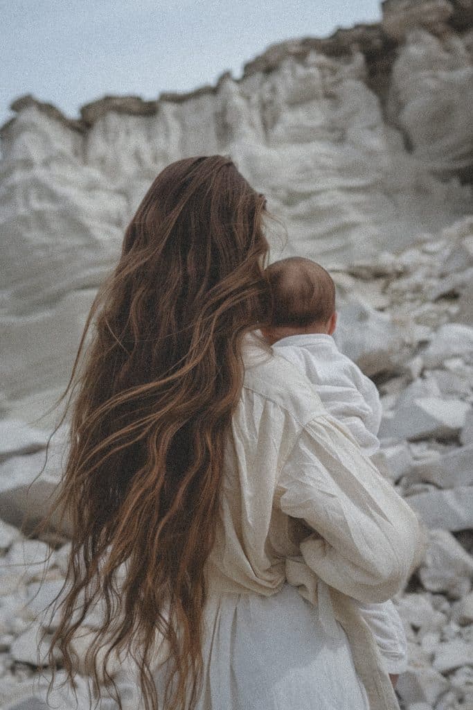 mother with baby on rocky cliff