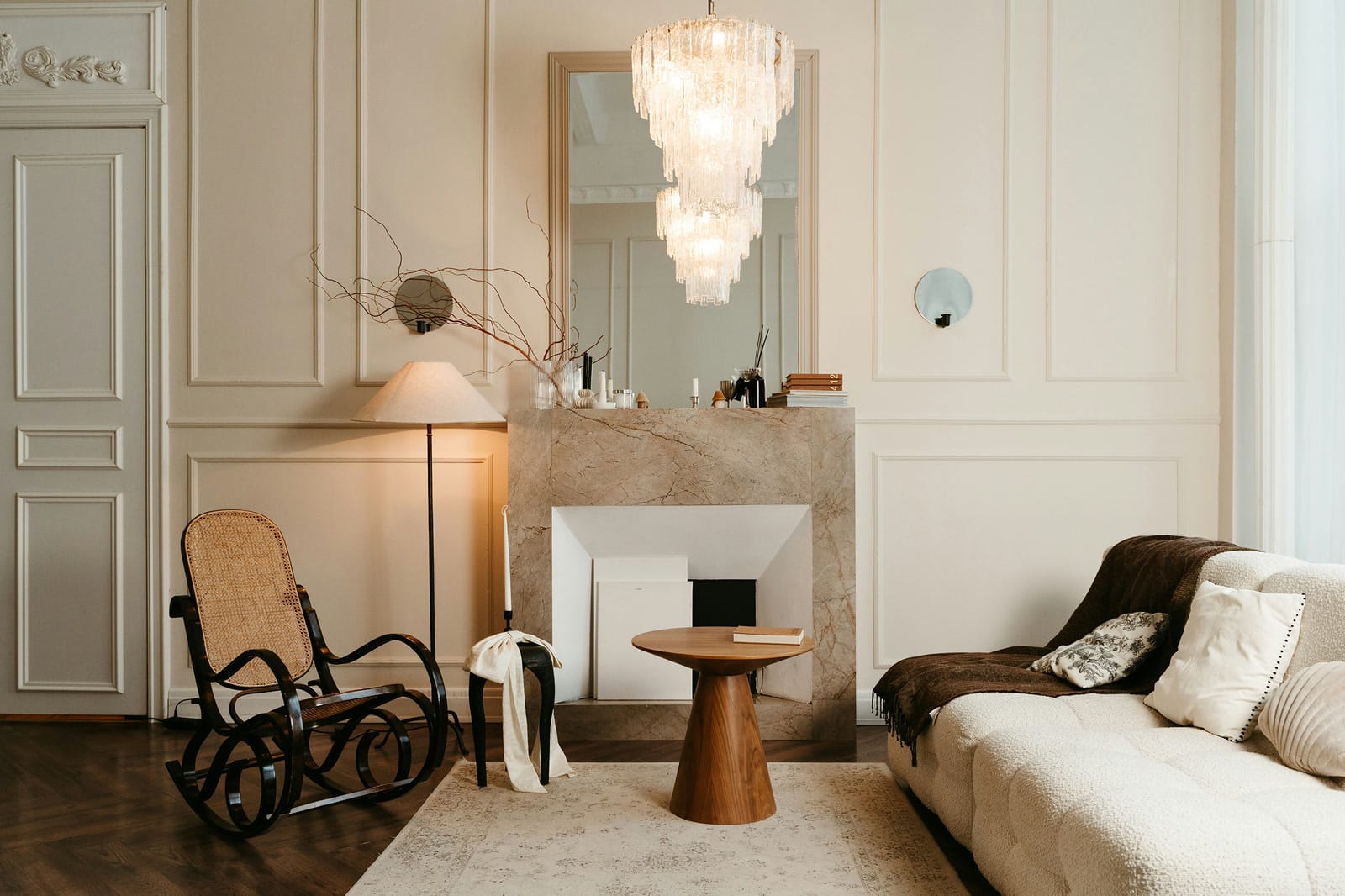 Elegant living room with a rocking chair, marble fireplace and crystal chandelier