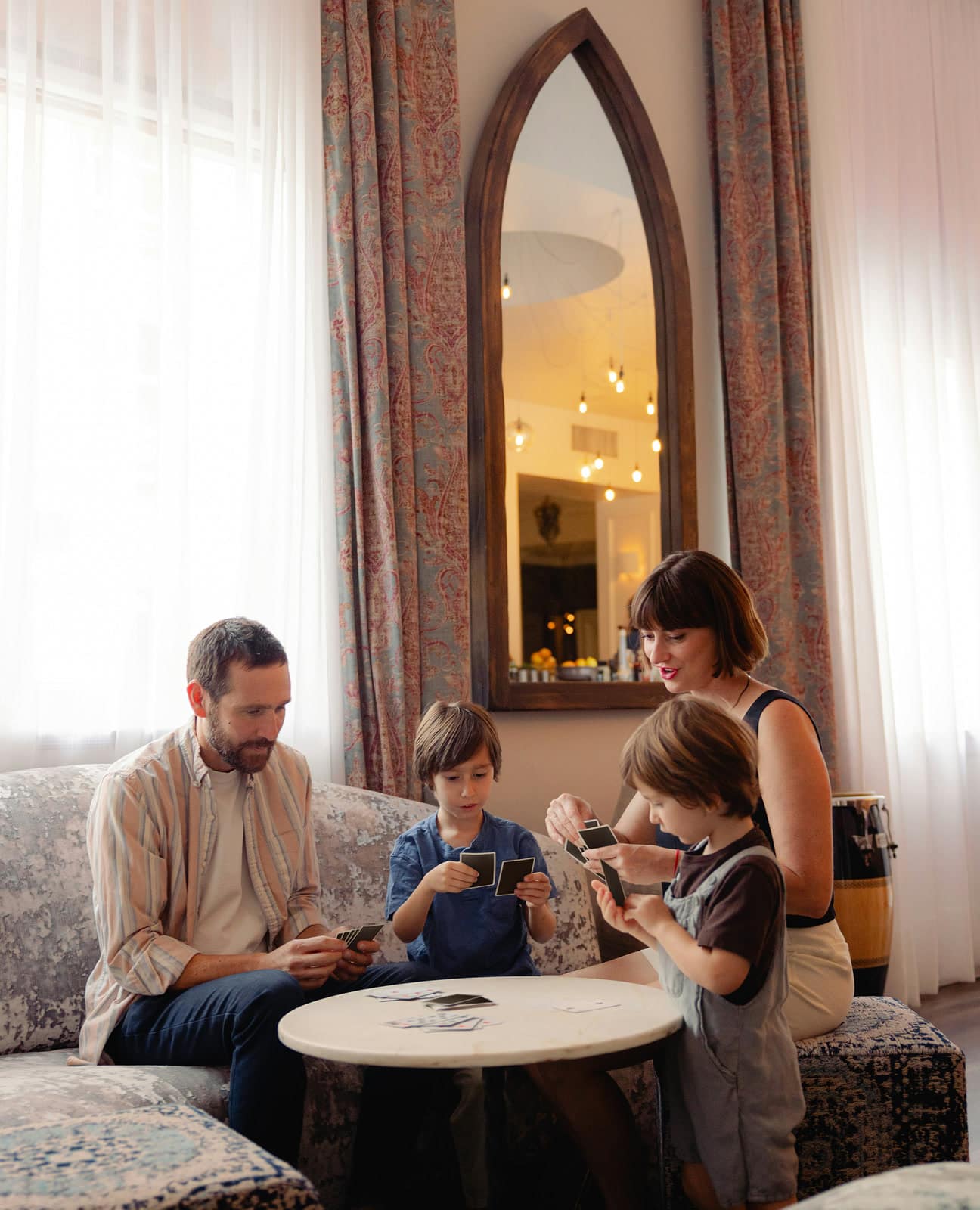 Family playing cards together around a marble table in an elegant living room